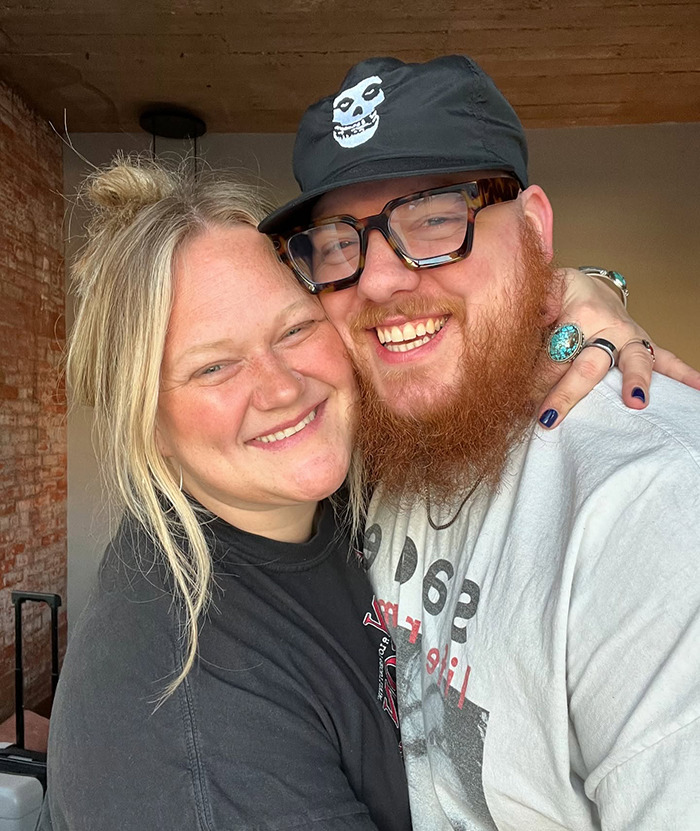 Couple smiling warmly in casual outfits, highlighting the viral shower clip trend. Couple smiling warmly in casual outfits, highlighting the viral shower clip trend.