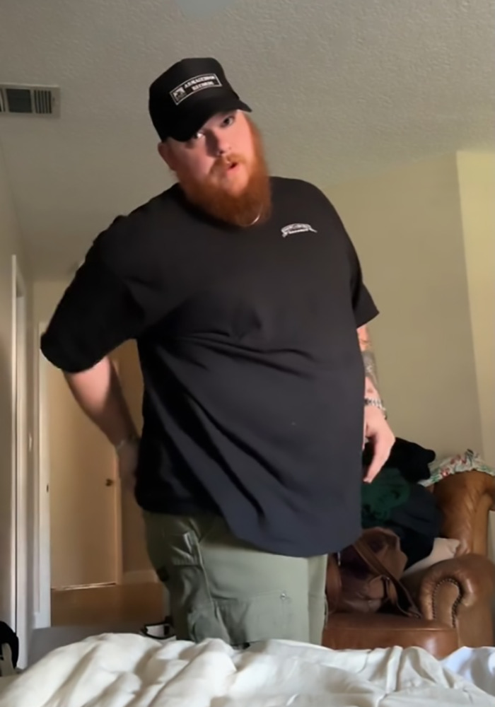 Man standing in a room wearing a black shirt and cap, illustrating a viral shower clip discussion among straight women. Man standing in a room wearing a black shirt and cap, illustrating a viral shower clip discussion among straight women.