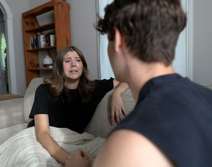 Woman upset on couch talking to man about lost dog experience. Woman upset on couch talking to man about lost dog experience.