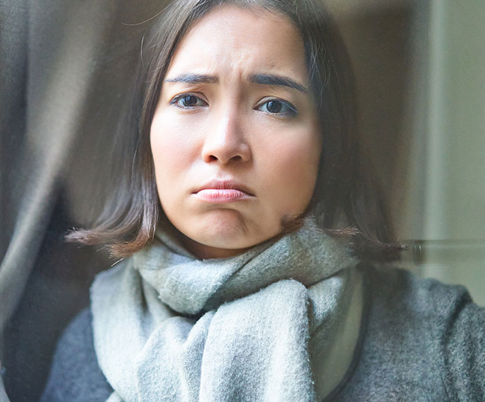 A woman with a sad expression, wrapped in a gray scarf, reflecting on advice after being rejected by her Zoomer friend. A woman with a sad expression, wrapped in a gray scarf, reflecting on advice after being rejected by her Zoomer friend.