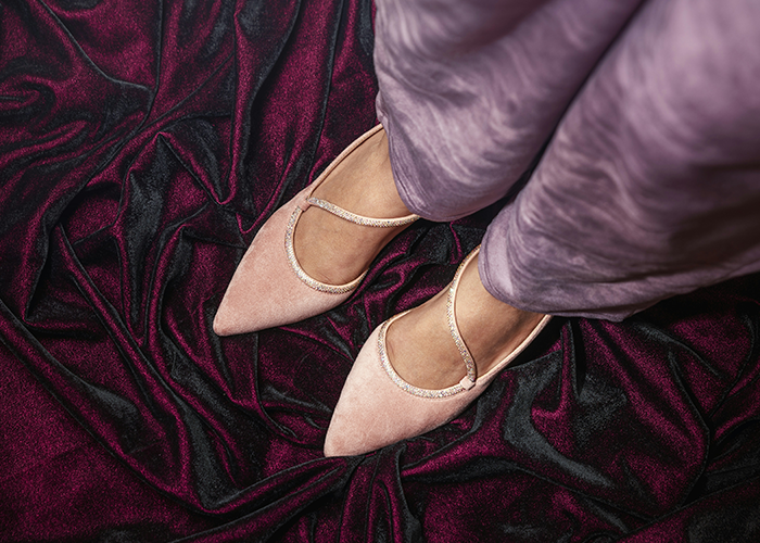 Woman wearing pink shoes standing on a purple velvet fabric. Woman wearing pink shoes standing on a purple velvet fabric.