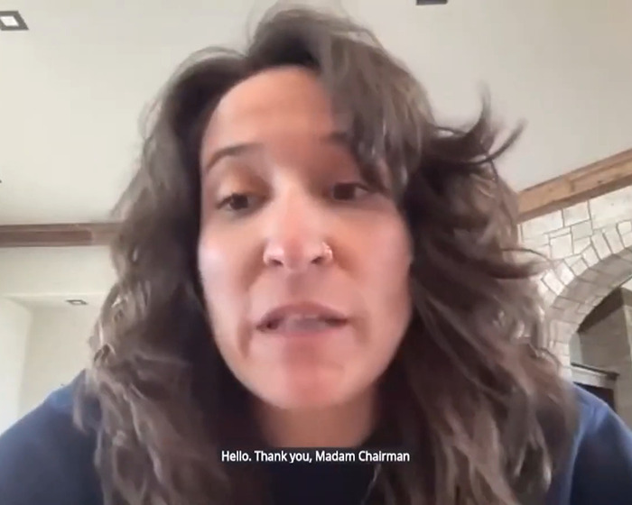 Britt Boril in video calls senator "Madam Chairman" in viral act of compliance, wearing casual attire with subtitles visible. Britt Boril in video calls senator "Madam Chairman" in viral act of compliance, wearing casual attire with subtitles visible.