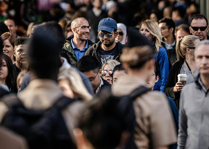Diverse crowd walking in a busy street, highlighting similar fashion trends among influencers and society's direction. Diverse crowd walking in a busy street, highlighting similar fashion trends among influencers and society's direction.