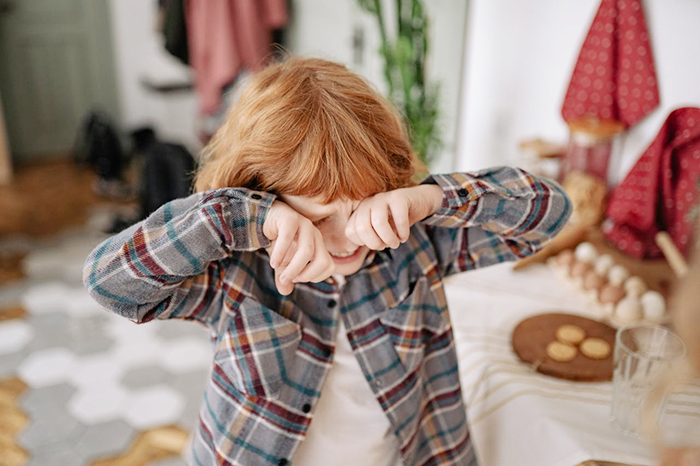 Child in plaid shirt wiping eyes, highlighting parenting guidance beyond "Big Boys Don’t Cry" stereotypes. Child in plaid shirt wiping eyes, highlighting parenting guidance beyond "Big Boys Don’t Cry" stereotypes.