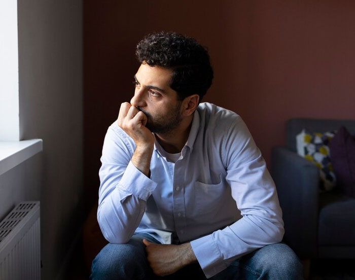 A man in a light shirt looks thoughtfully out the window, pondering a promotion decision. A man in a light shirt looks thoughtfully out the window, pondering a promotion decision.