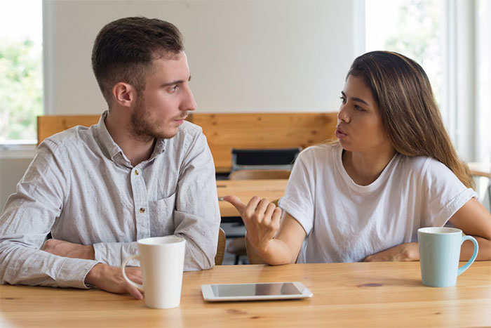 Couple discussing career promotion at a table with coffee and a tablet. Couple discussing career promotion at a table with coffee and a tablet.