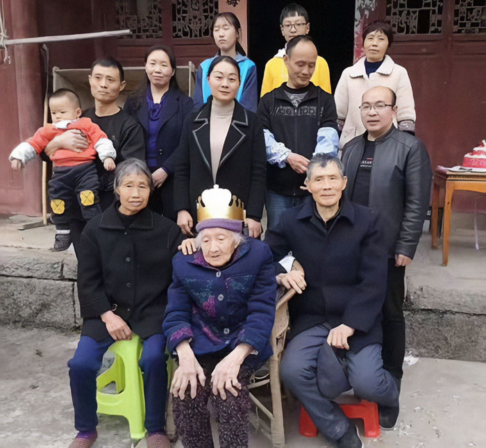 Elderly Chinese woman with family gathers around for a group photo. Elderly Chinese woman with family gathers around for a group photo.