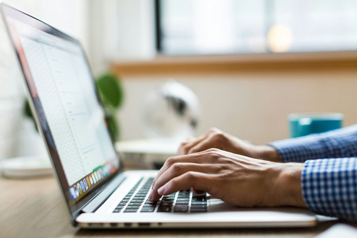 A person typing on a laptop at a desk with a blurred background, focused on writing about gay marriage and religion. A person typing on a laptop at a desk with a blurred background, focused on writing about gay marriage and religion.
