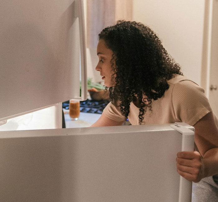 Person looking inside a refrigerator, checking for stuffed cheese bread. Person looking inside a refrigerator, checking for stuffed cheese bread.