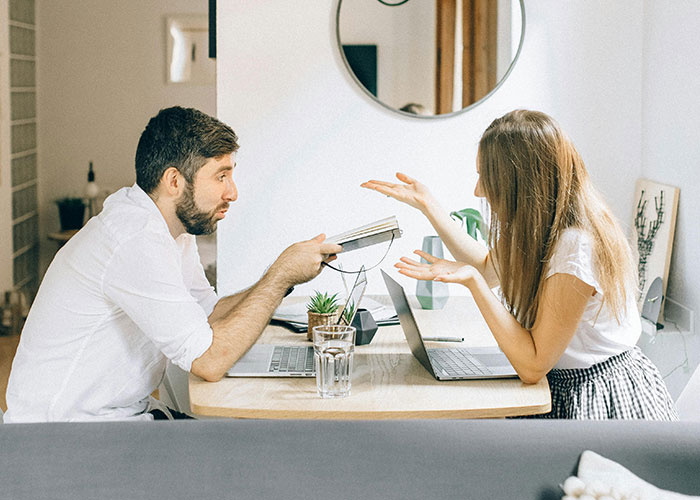 Man and woman having a discussion at a table with laptops, exploring property purchase ideas. Man and woman having a discussion at a table with laptops, exploring property purchase ideas.