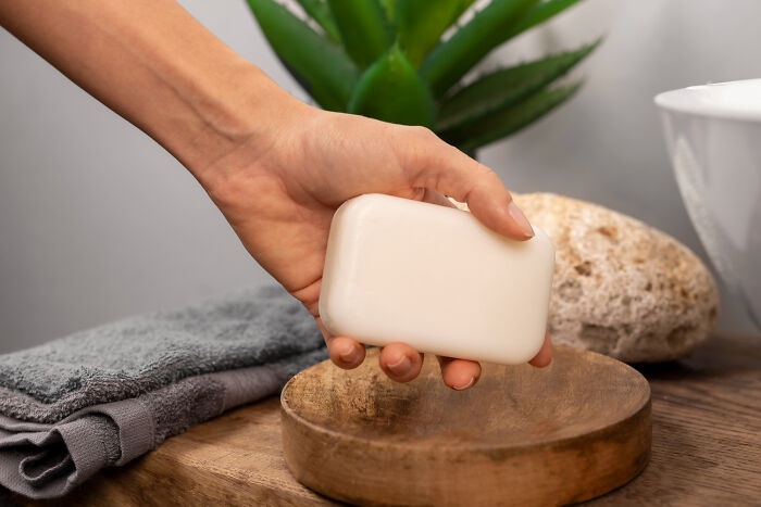 Hand holding soap bar in a bathroom setting, popular choice for harmless April Fools' pranks.
