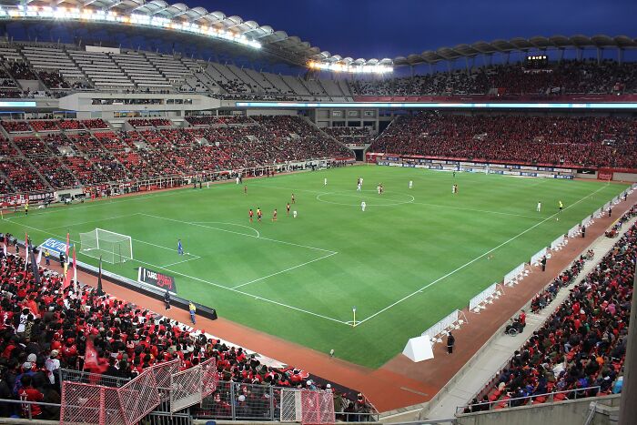 Large soccer stadium filled with fans during an evening match at one of the iconic cathedrals of soccer.