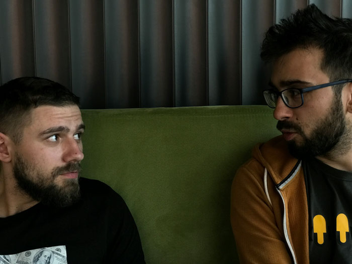 Two men on a couch having a discussion about opening a relationship. Two men on a couch having a discussion about opening a relationship.