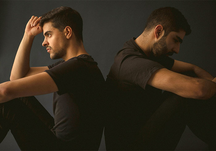 Two men sitting back-to-back, reflecting on ending a relationship. Two men sitting back-to-back, reflecting on ending a relationship.