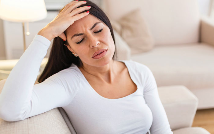 Woman in white shirt looking stressed, representing family tension over massive fortune inheritance. Woman in white shirt looking stressed, representing family tension over massive fortune inheritance.
