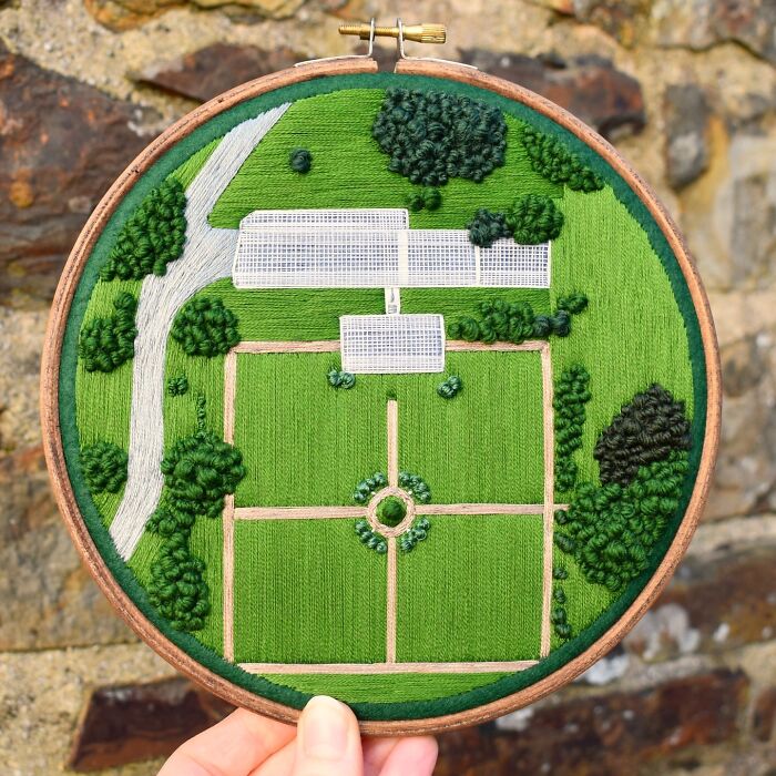 Landscape embroidery in a hoop by Victoria Rose Richards, depicting a lush green garden with pathways and shrubs.