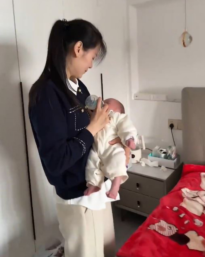 Young grandma, 39, holds and feeds a baby in a cozy room. Young grandma, 39, holds and feeds a baby in a cozy room.