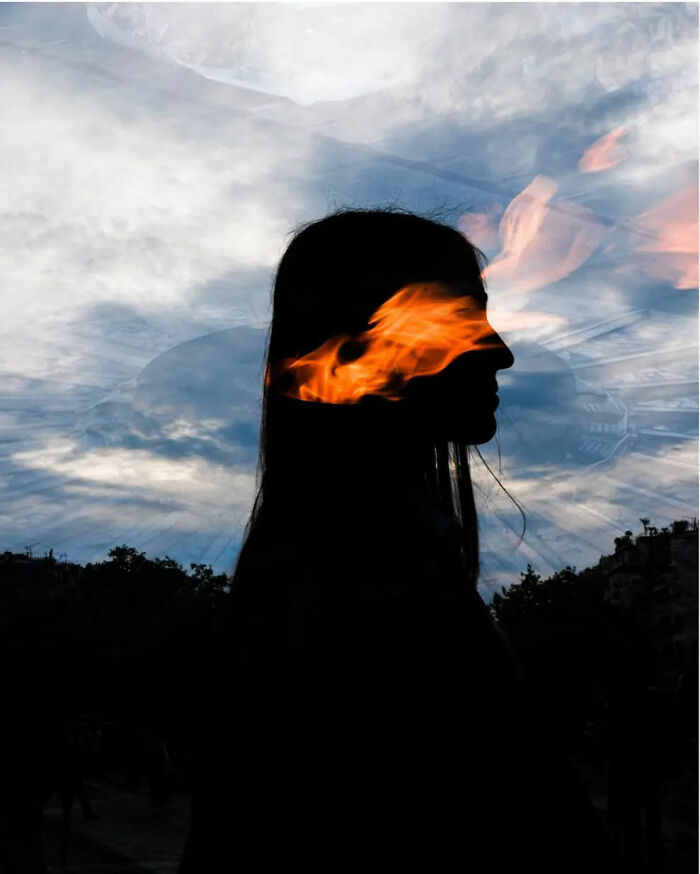 Silhouette with fiery element against a cloudy sky, capturing the raw beauty of street life photography.