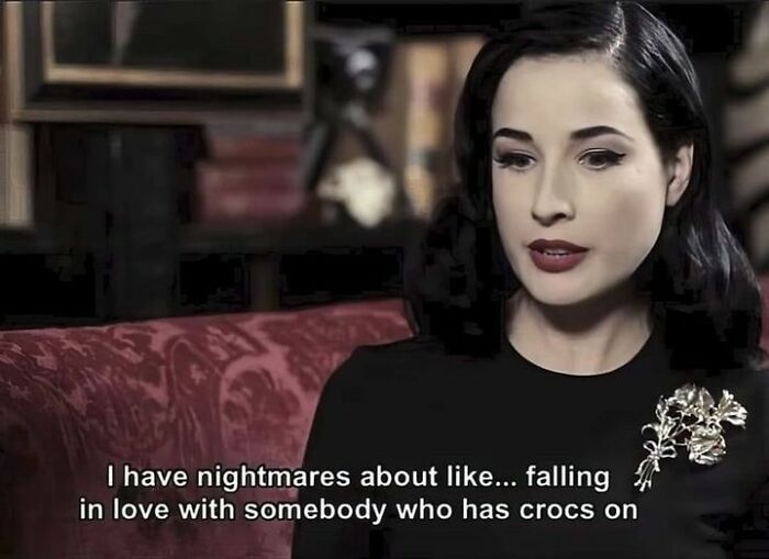 Woman in a black outfit sarcastically discussing nightmarish thoughts about Crocs; embodies spooky and sassy sarcasm.