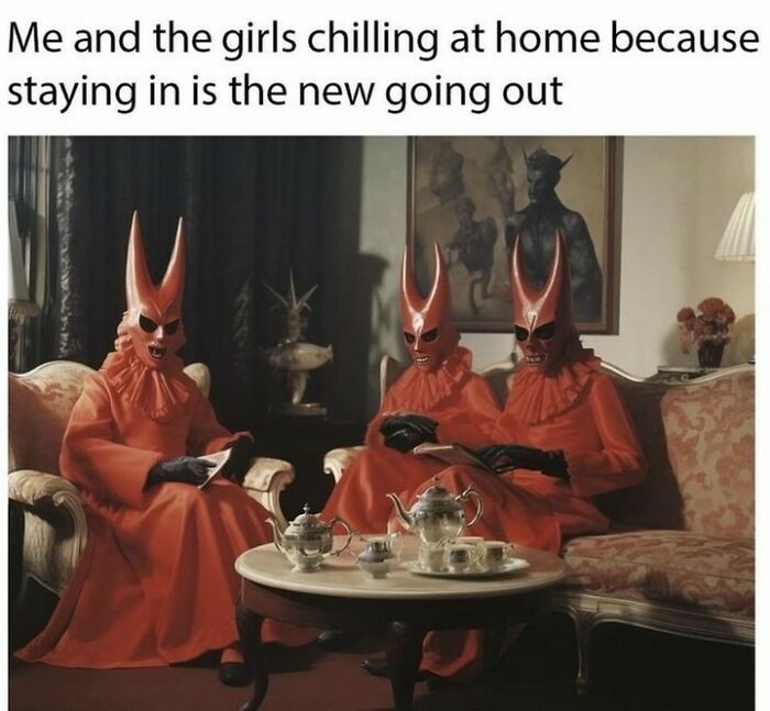 Three people in red devil costumes sitting in a living room, enjoying tea. Sarcasm and witchcraft vibes.