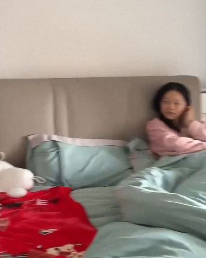 Pretty young woman, 39-year-old grandma, sitting in bed with pastel bedding, wearing a pink top, looking relaxed. Pretty young woman, 39-year-old grandma, sitting in bed with pastel bedding, wearing a pink top, looking relaxed.