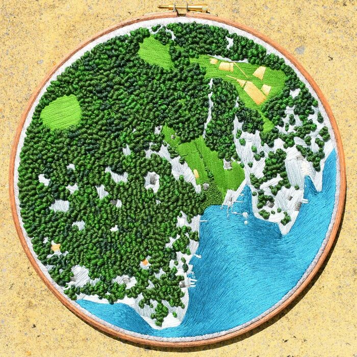 Embroidery art depicting a lush green landscape with ocean by Victoria Rose Richards.