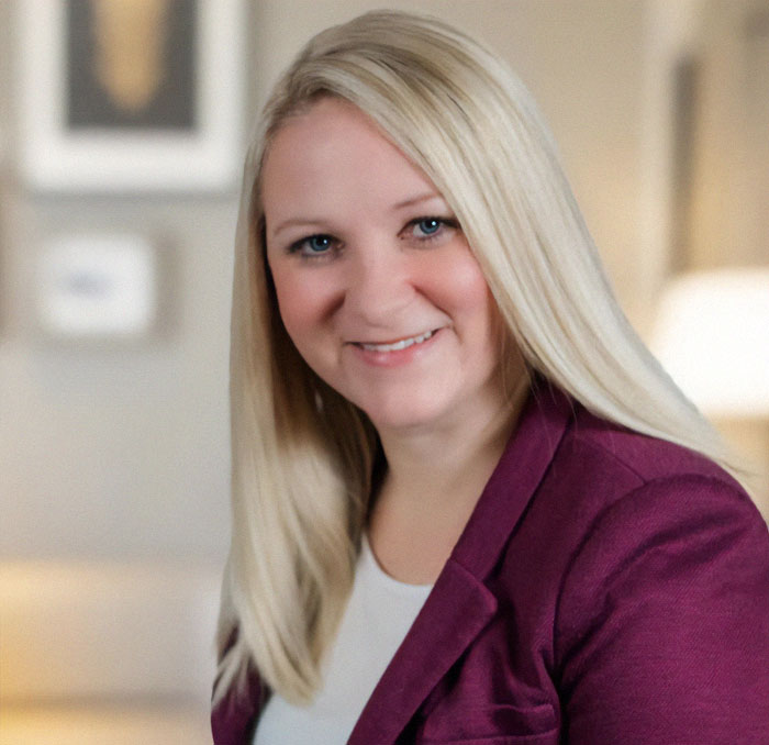 Blonde woman smiling, wearing a purple blazer, representing news on a woman's controversial restaurant bill incident. Blonde woman smiling, wearing a purple blazer, representing news on a woman's controversial restaurant bill incident.
