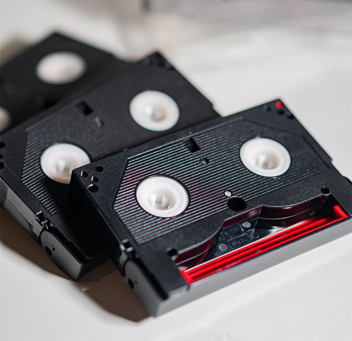 Cassette tapes on a table, symbolizing a father's plan to surprise his daughter with recordings of her late mother. Cassette tapes on a table, symbolizing a father's plan to surprise his daughter with recordings of her late mother.