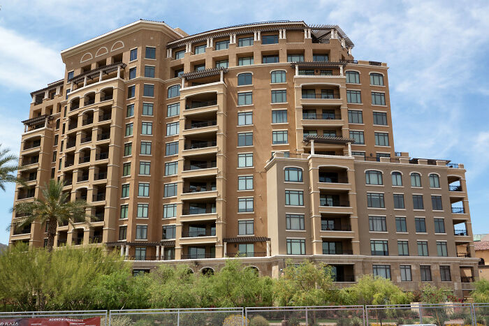 Tall beige touristy building surrounded by greenery, not worth the hype according to seasoned travelers.