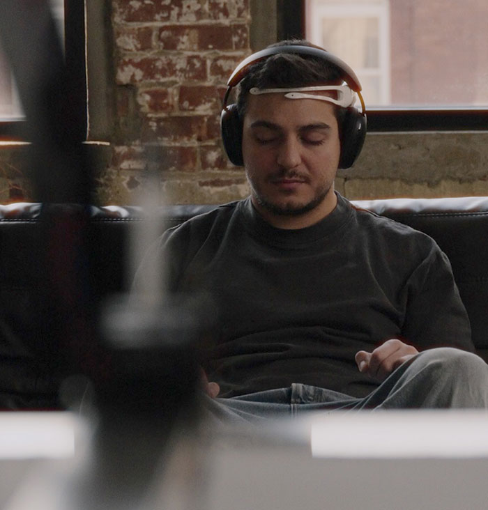 Person wearing headphones, eyes closed, capturing brain activity for unique tattoo imprint by an innovative artist. Person wearing headphones, eyes closed, capturing brain activity for unique tattoo imprint by an innovative artist.