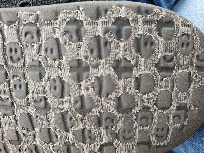 Worn shoe sole showing smiley face pattern, highlighting everyday things-used-over-time.
