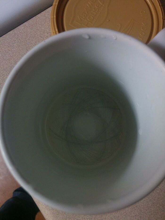 Close-up of a scratched coffee cup base, showing a blend of time-worn and everyday items.