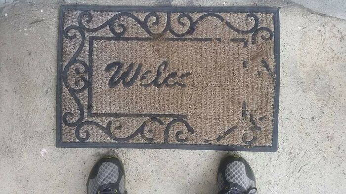 Worn doormat with "Welc" text showing wear, two shoes visible at the bottom, illustrating Time vs. Things.