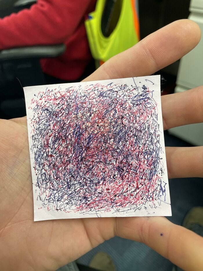 Hand holding a small paper with multicolored scribbles, illustrating creative abstraction about time vs. things.