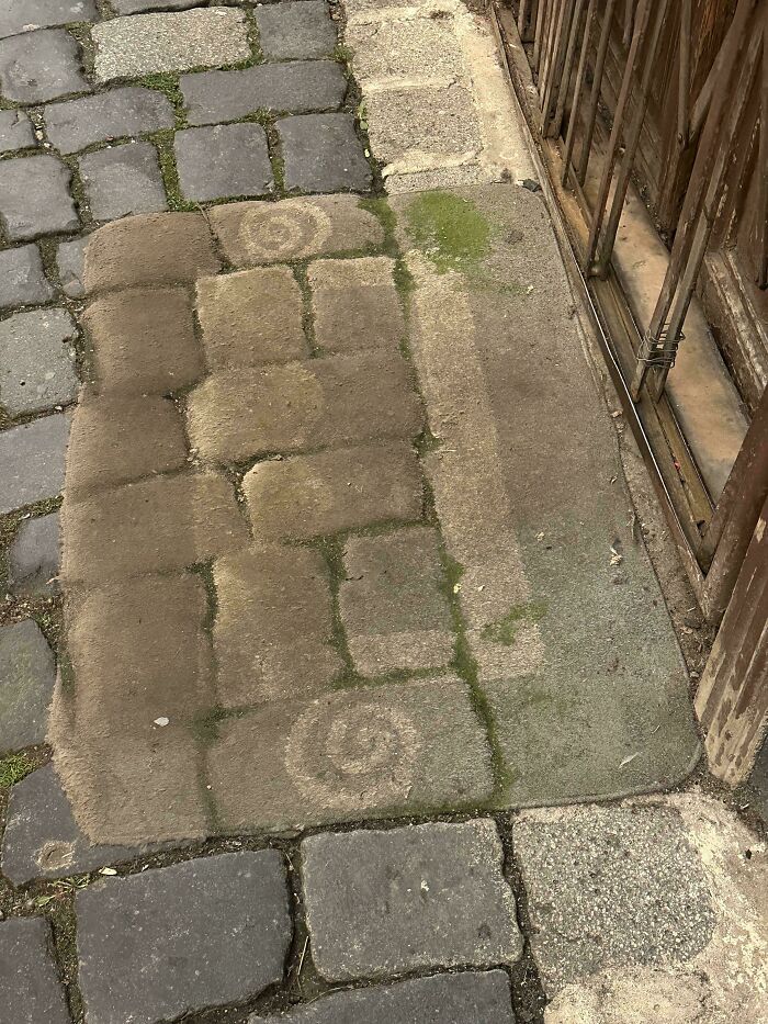 Worn doormat over paving stones, illustrating "Time vs. Things" through faded patterns and weathering effects.