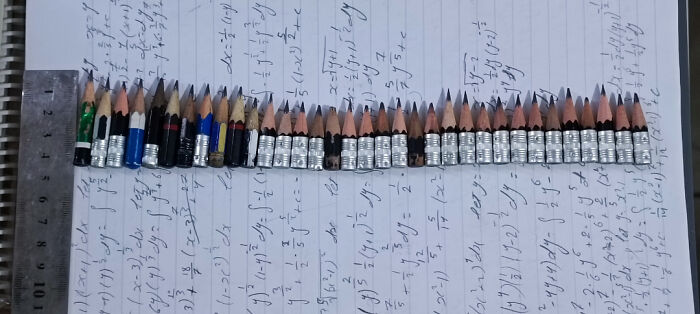 Sharpened pencil stubs aligned on paper with handwritten math notes, illustrating concept of time versus things.
