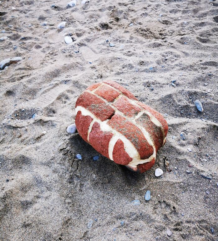 Rock resembling a loaf of bread on a sandy beach, highlighting the theme of time-vs-things.