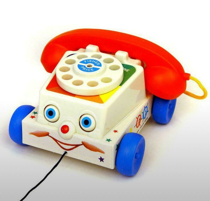 Vintage Fisher Price rotary toy phone with red handset and blue wheels, evoking nostalgic pics and memories of being old now.