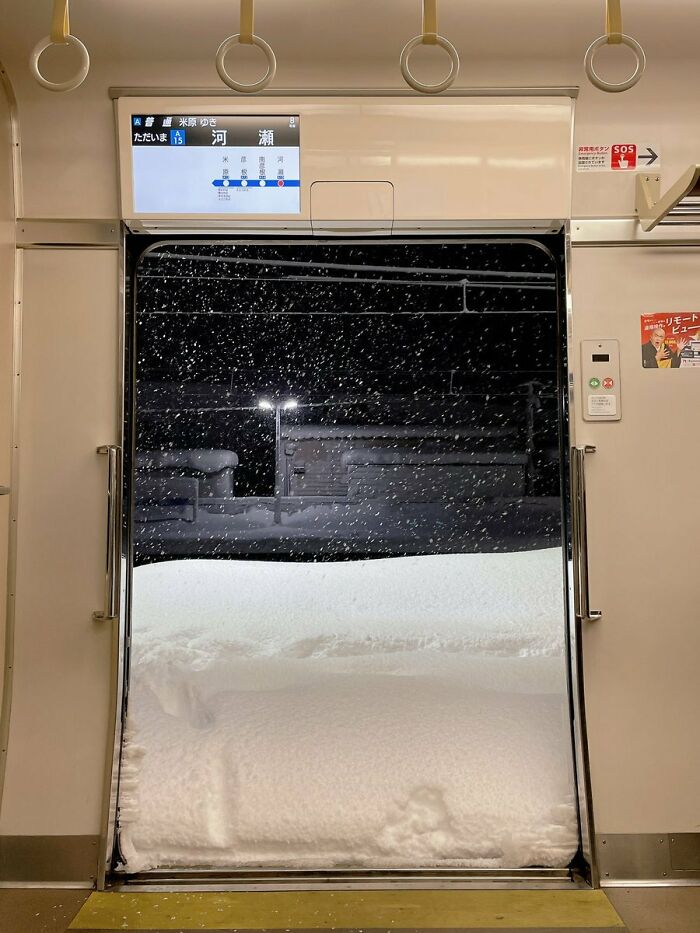 Train door opens to a massive snowdrift, highlighting nature's powerful and terrifying force.