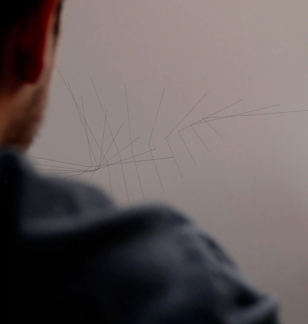 A person observes abstract lines on paper, symbolizing brain activity imprint in art. A person observes abstract lines on paper, symbolizing brain activity imprint in art.