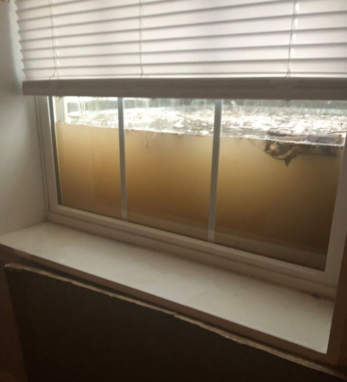 Floodwaters pressing against a basement window, showcasing nature's powerful force.