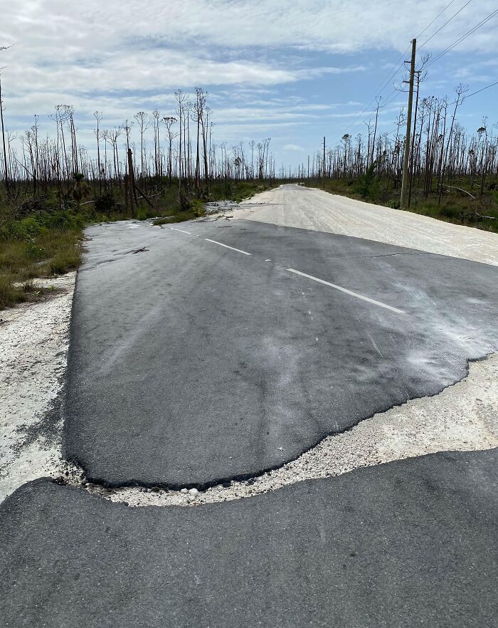 C*****d road amidst barren landscape showcasing nature's powerful force.