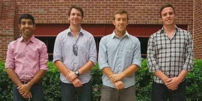 Four students developed a nail polish to detect d***s, standing in front of a brick wall.