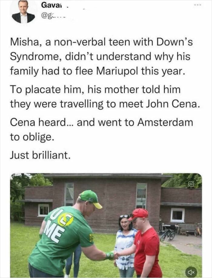 Person in green shirt meets a teen in a red shirt with Down's syndrome, showing a heartfelt connection.