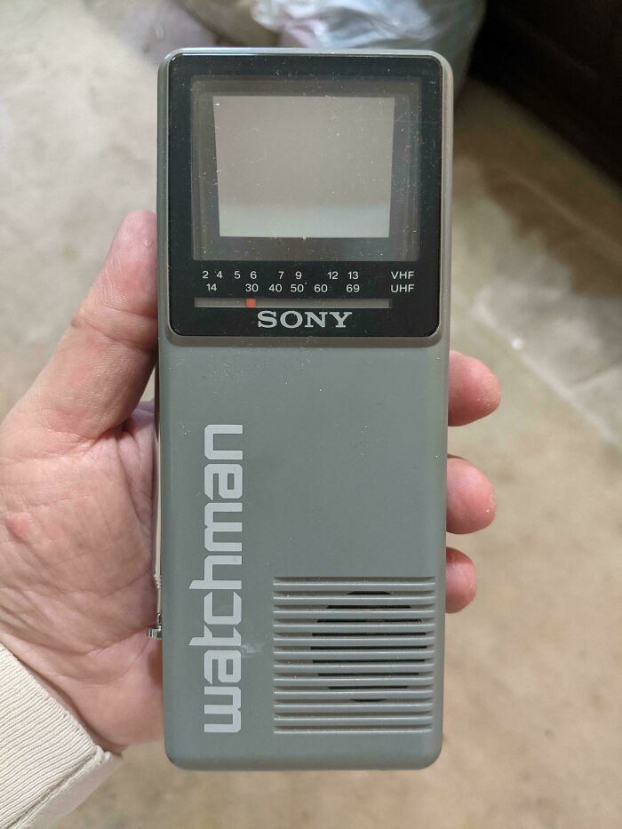 Hand holding a vintage Sony Watchman portable TV, a nostalgic device from people who just realized they’re old now.