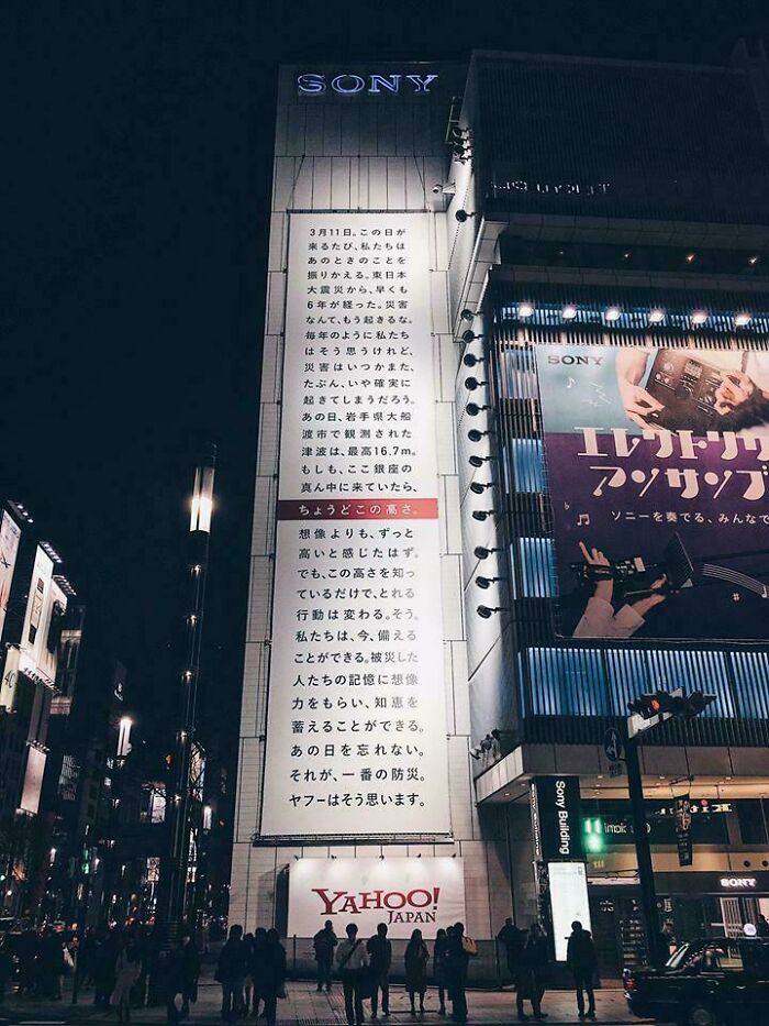Nighttime city street scene with large Sony and Yahoo Japan billboards showcasing innovative design features.
