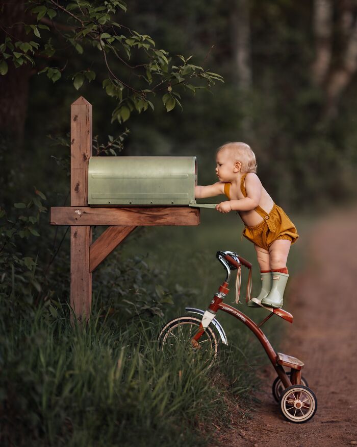Toddler standing on a tricycle, reaching into a mailbox, showcasing the magic of childhood exploration.