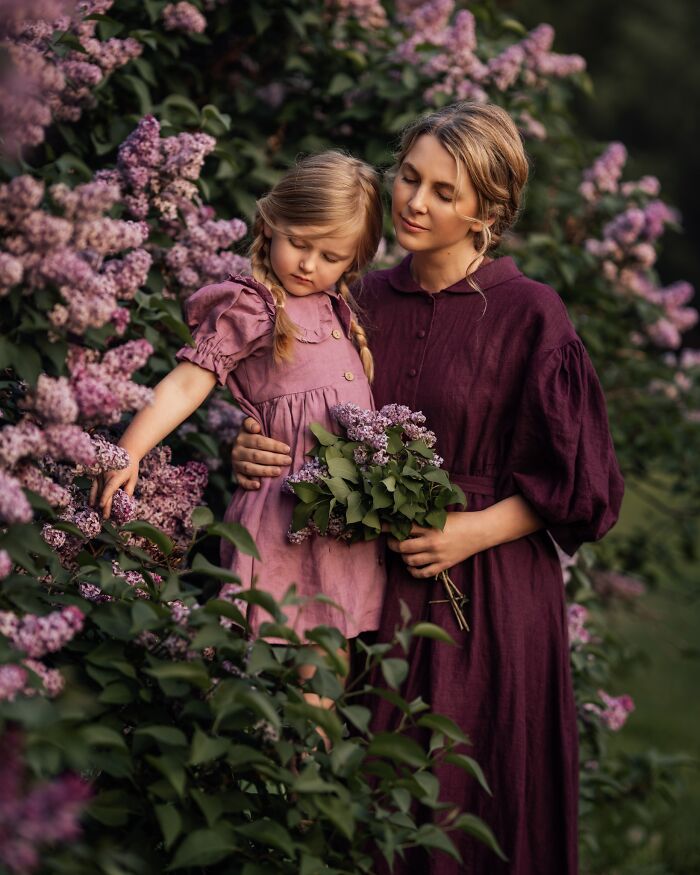 Mother and child in a garden, surrounded by lilacs, capturing the magic of childhood.