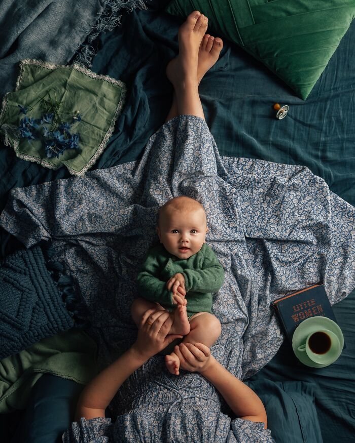 Mother and baby on a bed, capturing the magic of childhood with a book and cup of coffee nearby.