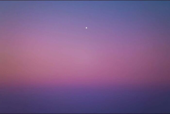 Mesmerizing astrophotography: a single star against a gradient night sky in shades of purple and pink.